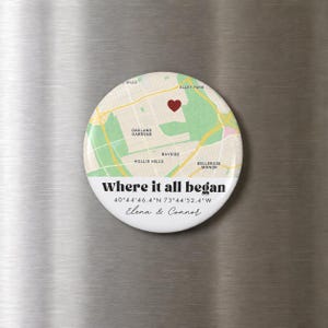 Peut inclure: Un aimant rond présentant une carte de Oakland Gardens, Hollis Hills et Bellerose Manor avec un cœur rouge. Le texte indique Where it all began, 40 44'46.4"N 73 44'52.4"W, ainsi que les prénoms Elena & Connor en noir et en écriture cursive.