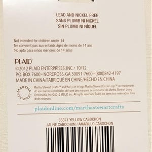 May include: A close-up of a product label for 35371 Yellow Cabochon. The label is white with black text and a barcode. The text on the label reads "Lead and Nickel Free", "Sans Plomb Ni Nickel", "Sin Plomo Ni Niquel", "Not intended for children under 14", "Ne convient pas aux enfants ages de moins de 14 ans", "No apto para ninos menores de 14 anos", "PLAID", "&copy;2012 PLAID ENTERPRISES, INC. 10/12", "P.O. BOX 7600 NORCROSS, GA 30091-7600 (800)842-4197", "MADE IN CHINA/FABRIQU&Eacute; EN CHINE/HECHO EN CHINA", "Martha Stewart Crafts&trade; and the/ y /et le logo Martha Stewart Circle Logo&trade; are trademarks of/ son marcas comerciales de/ sont des marques de commerce de Martha Stewart Living Omnimedia, Inc. &copy;2012 MSLO Inc. All rights reserved/ Todos los derechos reservados/Tous droits reserves.", "plaidonline.com/marthastewartcrafts", "35371 YELLOW CABOCHON", "JAUNE CABOCHON/AMARILLO CABOCHON".