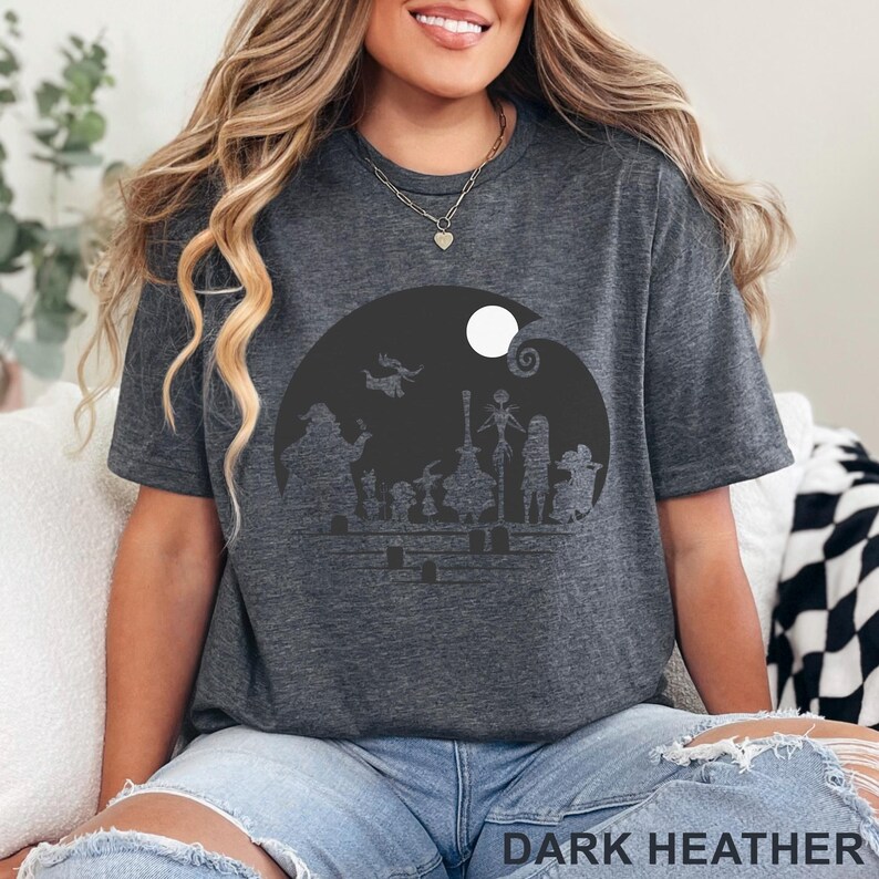Pu&ograve; includere: T-shirt grigio scuro melange con grafica nera di personaggi e luna piena. La grafica &egrave; inserita in un cerchio scuro. Il testo "DARK HEATHER" &egrave; stampato in basso sulla maglietta. La maglietta &egrave; in stile casual.