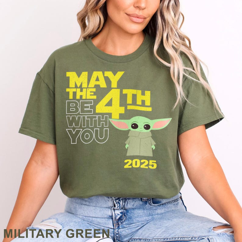 May include: A military green t-shirt with a yellow graphic that says "May the 4th Be With You" and features a green alien character. The year 2025 is printed below the graphic.