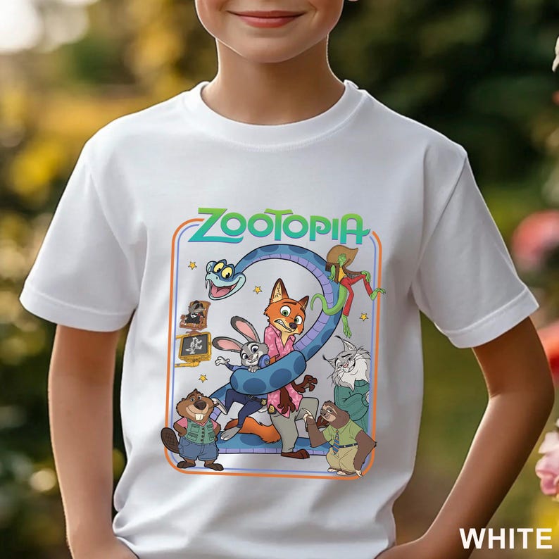 Pode incluir: Camiseta branca com um gr&aacute;fico colorido do filme de anima&ccedil;&atilde;o Zootopia. O design inclui o t&iacute;tulo do filme e v&aacute;rios personagens, como uma raposa, um coelho e uma cobra. A palavra "WHITE" est&aacute; impressa no canto inferior direito.
