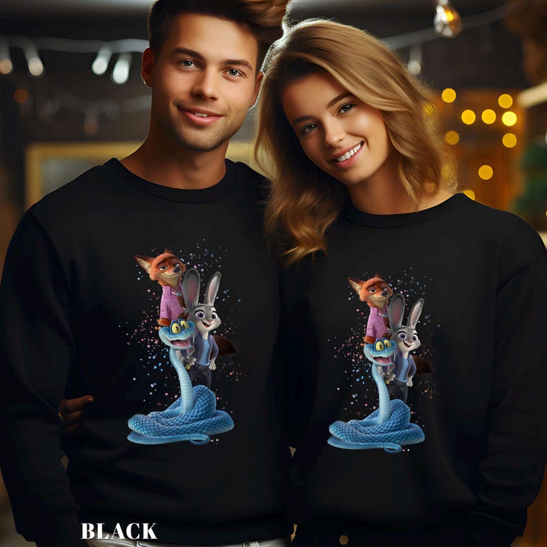 Peut inclure: Sweat-shirts noirs avec un graphisme color&eacute; de personnages de dessins anim&eacute;s. Le motif comprend un renard, un lapin et un serpent. Le mot "BLACK" est imprim&eacute; en bas du sweat-shirt.