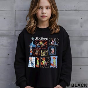 May include: Black sweatshirt featuring colorful cartoon characters from the movie "Zootopia." The word "Zootopia" is printed in white at the top. The sweatshirt has a crew neck and long sleeves. The word "BLACK" is printed in white at the bottom.
