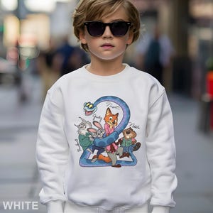 May include: White sweatshirt featuring a colorful cartoon graphic of animal characters and the number 2. The graphic includes a fox, rabbit, beaver, and other characters. The word "WHITE" is printed at the bottom.