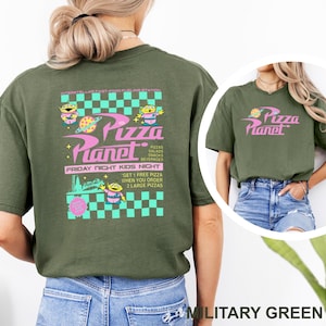 May include: Military green t-shirt with a Pizza Planet graphic. The design features the Pizza Planet logo in pink, with alien characters and text that reads "Friday Night Kids Night".