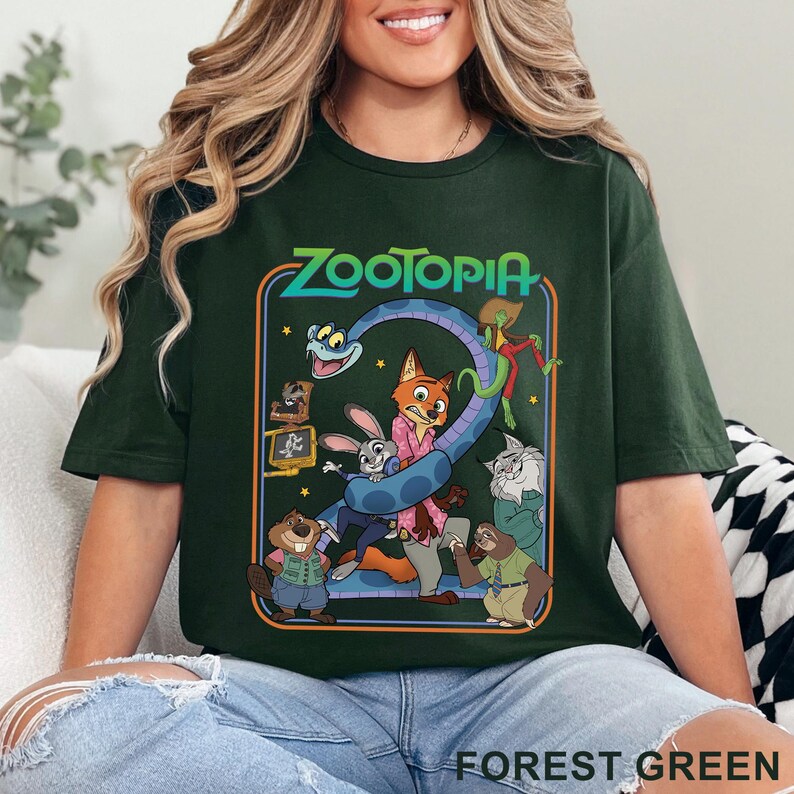 Pode incluir: Camiseta verde floresta com um gr&aacute;fico colorido do filme Zootopia. O design inclui o t&iacute;tulo do filme e v&aacute;rios personagens animais. A camiseta tem gola redonda e mangas curtas.