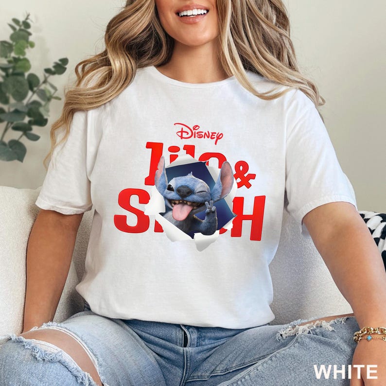 Puede incluir: Camiseta blanca con el personaje de Disney Stitch, con las palabras "Lilo & Stitch" en rojo. Stitch se muestra sacando la lengua y haciendo la se&ntilde;al de la paz. La palabra "WHITE" est&aacute; impresa en la parte inferior.