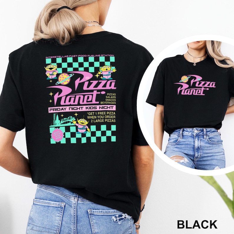 May include: Black t-shirt with a Pizza Planet graphic. The design features the words "Pizza Planet" in pink and a cartoon alien. Additional text includes "Friday Night Kids Night" and "Get 1 Free Pizza When You Order 2 Large Pizzas."