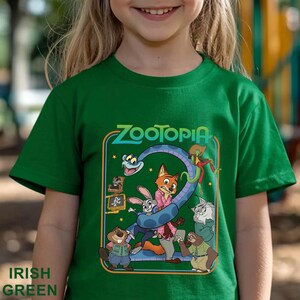 Pode incluir: T-shirt verde irland&ecirc;s com a palavra "Zootopia" e personagens de desenhos animados. A camiseta tem gola redonda e mangas curtas. As palavras "Irish Green" s&atilde;o impressas na parte inferior.