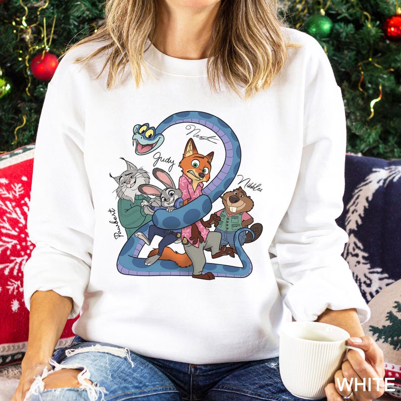 May include: White sweatshirt with a cartoon graphic of characters from a movie. The design includes a blue snake wrapped around the characters, with the names "Nick", "Judy", "Nibbles", and "FruFru" written on the design.