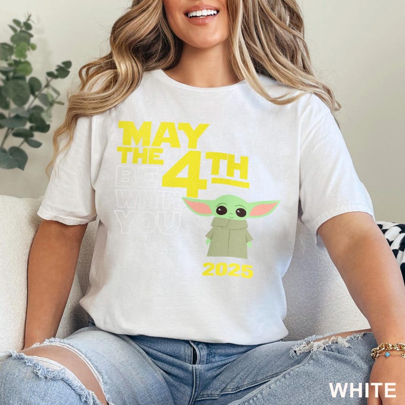 May include: White t-shirt with a yellow graphic that says "May the 4th Be With You" and a green Baby Yoda character. The year 2025 is printed below the character.