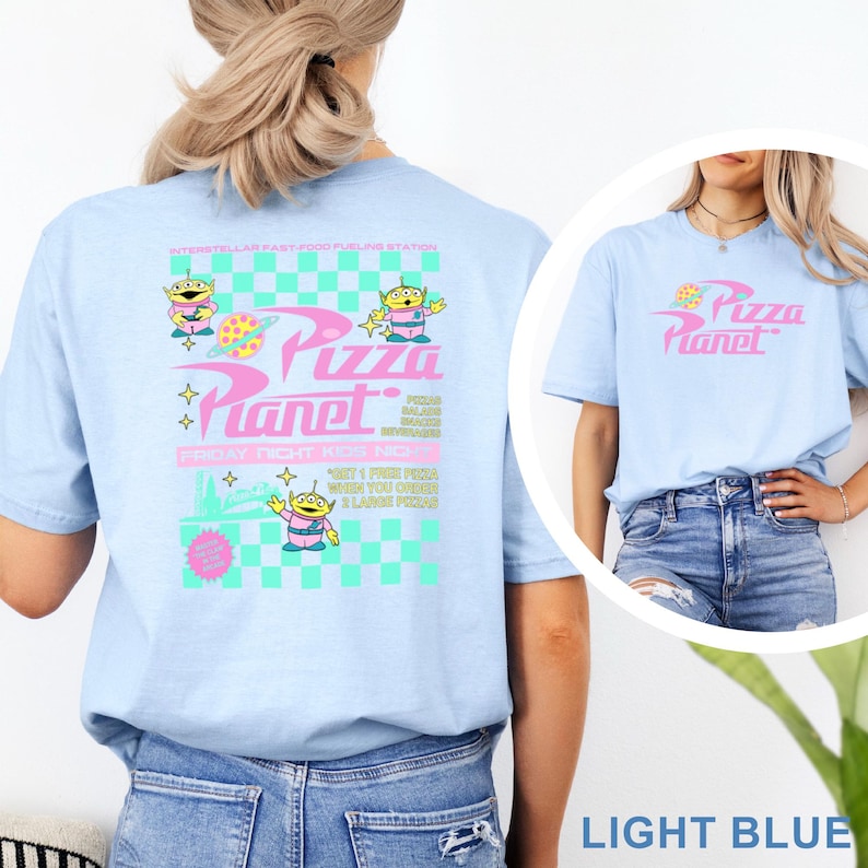 May include: Light blue t-shirt featuring the Pizza Planet logo and alien characters. The back of the shirt has a graphic with the text "Pizza Planet" and "Friday Night Kids Night". The shirt is made of a soft material.