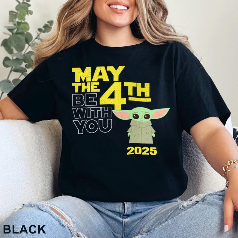 May include: Black t-shirt with a yellow graphic that says "May the 4th Be With You" and features a green alien character. The year 2025 is printed below the character.