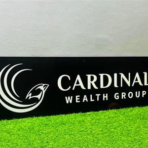 Peut inclure: Panneau rectangulaire noir avec l'inscription blanche "CARDINAL WEALTH GROUP". Le panneau présente un graphisme blanc d'oiseau dans un design incurvé. Le panneau est posé sur un lit d'herbe artificielle verte.