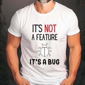 May include: White t-shirt with black text that reads "It's not a feature it's a bug" and a black and white bug illustration.