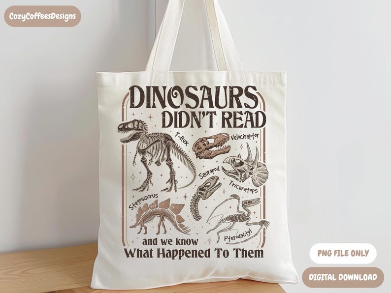 May include: Cream-colored tote bag featuring a dinosaur-themed design. The design includes dinosaur skeletons and the text "DINOSAURS DIDN'T READ and we know What Happened To Them". The bag has two handles and is made of a canvas-like material.