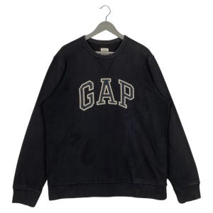 May include: Black long-sleeved sweatshirt with a large, white "GAP" logo on the front.