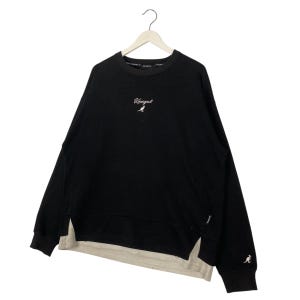 May include: Black sweatshirt with the Kangol logo in white script on the chest. The sweatshirt has a split hem design with a cream-colored underlayer. The Kangol logo is also on the sleeve.