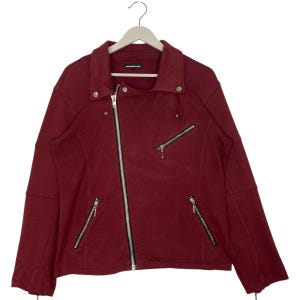 May include: A burgundy jacket with a diagonal zipper closure and multiple silver zippers. The jacket has a wide collar and is hanging on a white hanger. The jacket has a casual, yet edgy style.