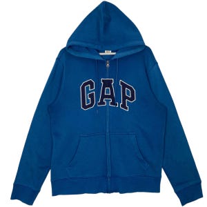May include: A blue zip-up hoodie with a hood and front pockets. The word "GAP" is across the chest in navy blue with a white outline. The hoodie is made of a soft material.