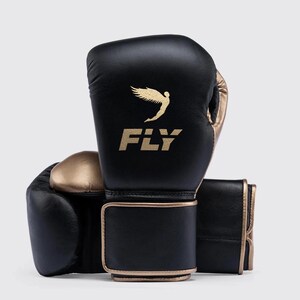 Fly boxing gloves made from premium genuine leather, designed for professional sparring and training sessions. The gloves feature thick multi-layer foam padding for impact protection, secure wrist support with Velcro or lace-up closure, and a comfortable inner lining for extended workouts. Ideal for boxing, bag work, and gym training, offering durability, performance, and a sleek professional fight-style design for men and women athletes.