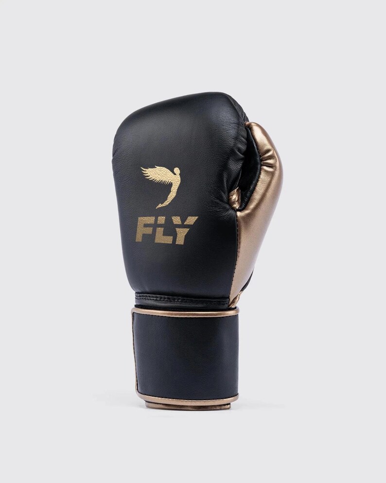 Fly boxing gloves made from premium genuine leather, designed for professional sparring and training sessions. The gloves feature thick multi-layer foam padding for impact protection, secure wrist support with Velcro or lace-up closure, and a comfortable inner lining for extended workouts. Ideal for boxing, bag work, and gym training, offering durability, performance, and a sleek professional fight-style design for men and women athletes.