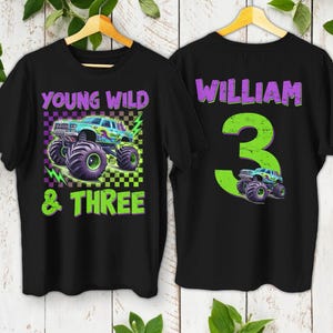 May include: Two black t-shirts with a monster truck theme. One shirt features the text "YOUNG WILD & THREE" with a monster truck graphic. The other shirt has the name "WILLIAM" and the number "3" with a monster truck graphic.