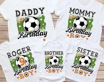 Op de afbeelding: Witte T-shirts met groene en oranje voetbalthema-ontwerpen. De shirts zeggen "Daddy of the Birthday Boy", "Mommy of the Birthday Boy", "Roger of the Birthday Boy", "Brother of the Birthday Boy" en "Sister of the Birthday Boy".