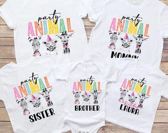 Puede incluir: Conjunto de cuatro camisetas blancas con un gráfico colorido de "animal de fiesta" e ilustraciones de animales. Las camisetas están etiquetadas como "Mamá", "Hermana", "Hermano" y "Laura cumpleaños".