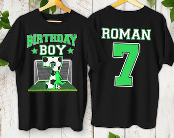 May include: Black t-shirt with green text that says "Birthday Boy" and a soccer player with a soccer ball in front of a goal. The back of the shirt has green text that says "Roman 7".