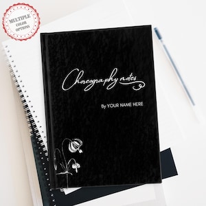 May include: Black notebook with the text "Choreography notes" in white cursive script. The text "By YOUR NAME HERE" is also in white below the title. A white floral design is in the bottom left corner.