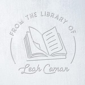 Op de afbeelding: Een wit exlibris met de tekst "From the Library of Leah Coman" en een gestileerde afbeelding van een open boek.