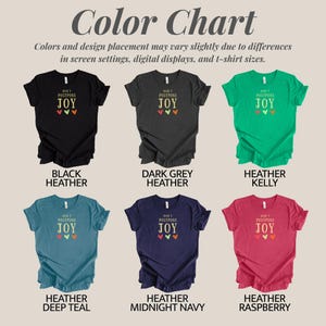 May include: A color chart displaying six short-sleeved t-shirts in black heather, dark grey heather, heather kelly, heather deep teal, heather midnight navy, and heather raspberry. Each shirt features the text DON'T POSTPONE JOY and three small hearts.