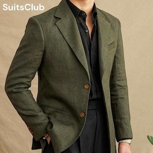 Op de afbeelding: Olijfgroene blazer met twee bruine knopen, gecombineerd met een zwart overhemd en een zwarte broek. De blazer heeft een klassieke revers en een zak. Het SuitsClub-logo is linksboven zichtbaar.