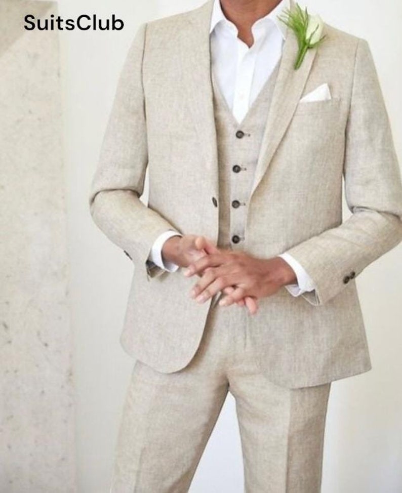 Pu&ograve; includere: Un completo in lino beige a tre pezzi, composto da giacca, gilet e pantaloni. La giacca ha un revers a lancia e un fazzoletto da taschino. Sotto &egrave; indossata una camicia bianca. Il logo SuitsClub &egrave; visibile. Un fiore &egrave; appuntato all'occhiello.