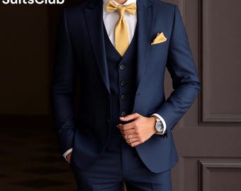 May include: A navy blue suit with a matching vest and a gold bow tie. The suit has a pocket square in the breast pocket.