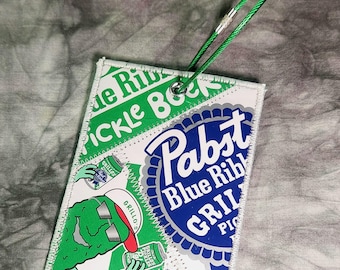Etiqueta grande para equipaje hecha con envases reciclados de cerveza Pabst Blue Ribbon Grillio's Pickle.