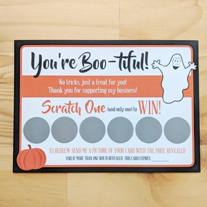 Może przedstawiać: Czarno-pomarańczowa karta do zdrapywania z motywem Halloween z ilustracją ducha i tekstem "You're Boo-tiful!"  "No tricks, just a treat for you!" "Thank you for supporting my business!" "Scratch One (and only one) to WIN!"  "To redeem: Send me a picture of your card with the prize revealed. Void if more than one box is revealed. This card expires___."