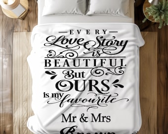 Könnte beinhalten: Weiße Decke mit schwarzer Schrift, die lautet: "Every Love Story is Beautiful But OURS is my favourite Mr & Mrs Brown". Die Decke liegt auf einem Bett mit weißen Kissen. Die Decke ist gefaltet.