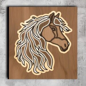 Puede incluir: Una cabeza de caballo tallada en madera, con una melena fluida. El caballo est&aacute; mirando hacia la derecha, y la melena ondea al viento. La talla es detallada y realista.