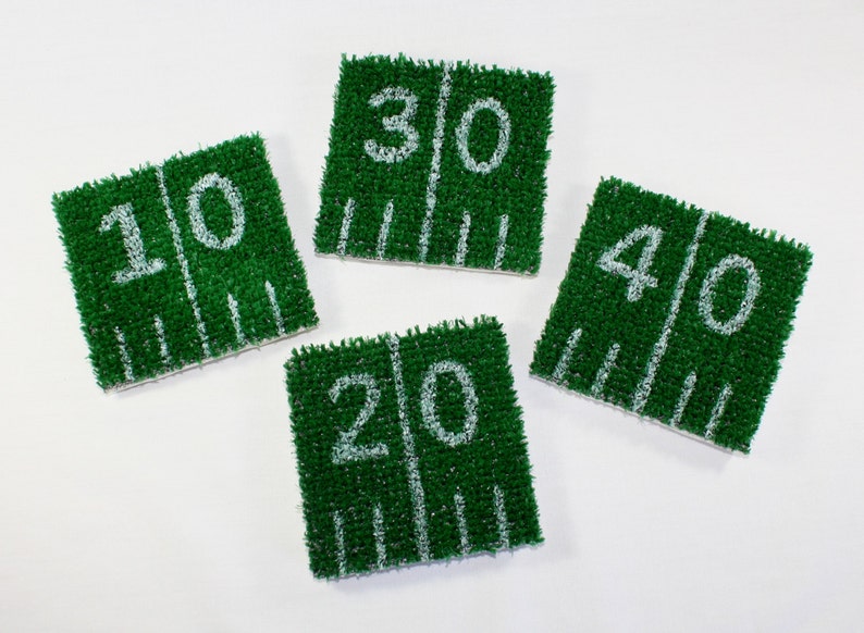 May include: Four green and white felt football field yard markers. The markers are numbered 10, 20, 30, and 40.