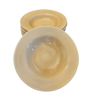 May include: A collection of beige ceramic bowls with a wide rim. The bowls have a slightly textured surface and a shallow, rounded interior. These bowls are suitable for serving soups, pasta, or salads.