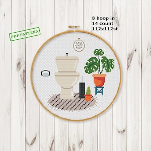 Puede incluir: Patrón de punto de cruz en un aro de 20 cm, que representa un inodoro, una planta en maceta y el texto "Have a Nice Poop". El diseño incluye una pequeña alfombra y un portarrollos de papel higiénico. También se ve el texto "PDF PATTERN".