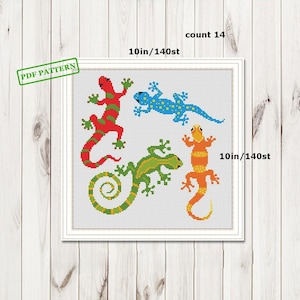 May include: A framed cross-stitch pattern showing four lizards in red, blue, green, and orange. The design is 25 cm square and includes the text "PDF PATTERN" and "count 14".