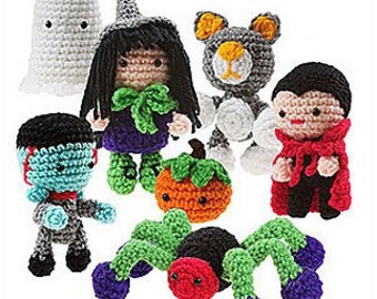 May include: A set of crocheted amigurumi monster toys, including a ghost, witch, cat, vampire, pumpkin, and spider. The toys are all in various colors and have cute facial expressions. The title "Monster Mash Amigurumi" is displayed at the top of the image.
