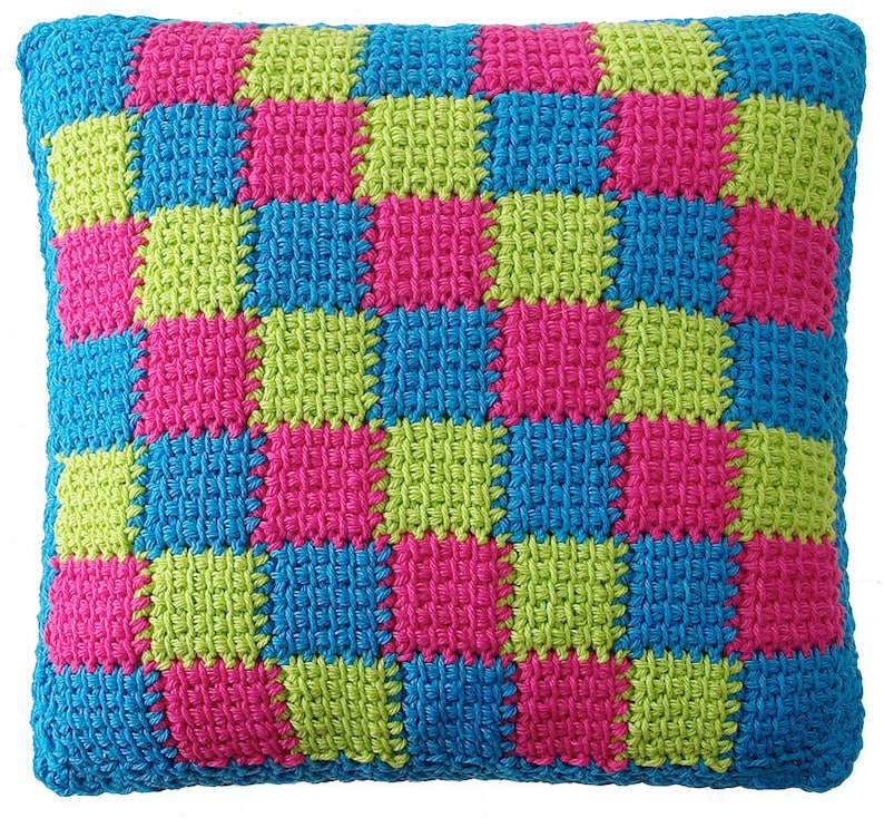 May include: A square-shaped pillow with a checkered pattern in bright pink, green, and blue.