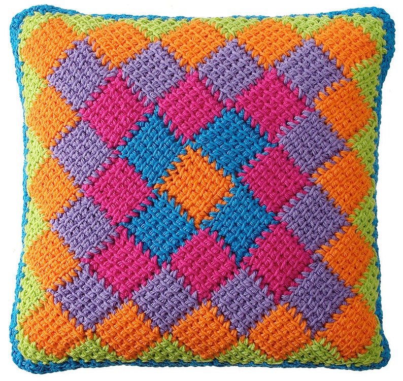 May include: A colorful crocheted pillow with a diamond pattern in shades of green, orange, purple, pink, and blue.