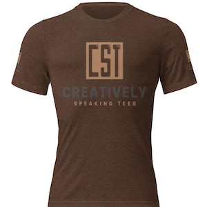 May include: Brown t-shirt with the text "CST CREATIVELY SPEAKING TEES" in a square design. The shirt is a solid brown color and has short sleeves. The text is in a combination of brown and gray.
