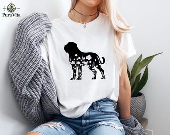 May include: White t-shirt featuring a black silhouette of a dog filled with floral designs. The shirt is paired with blue jeans. The brand logo "Pura Vita" is visible in the upper left corner of the image.