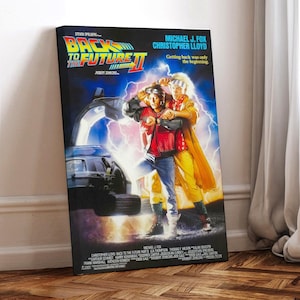 Peut inclure: Une affiche de film pour Retour vers le futur 2 avec Michael J. Fox et Christopher Lloyd. L'affiche a un fond noir avec une ville futuriste et une DeLorean. Le texte sur l'affiche indique "Retour vers le futur 2" et "Revenir en arrière n'était que le début."